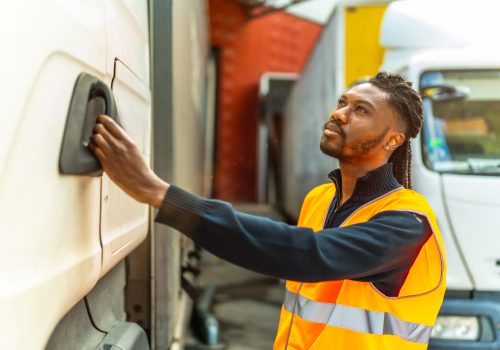 Side view of an African driver opening the door of the truck
