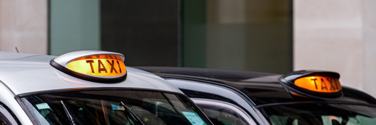 A british london black taxi cab sign with defocused  background - image